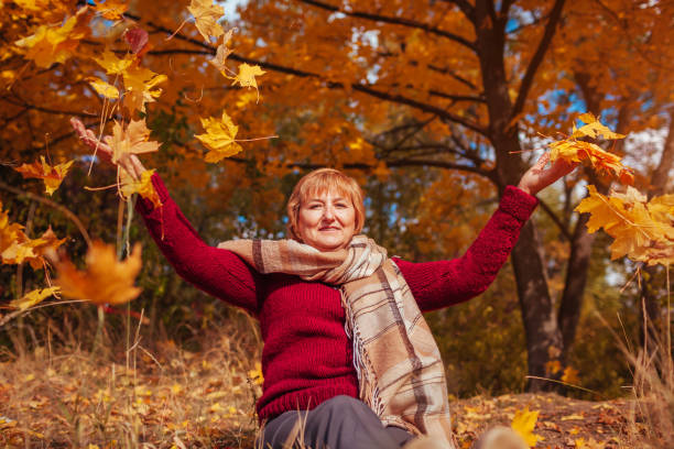 istock Middle-aged woman throwing leaves in the forest 861340638