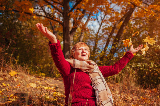istock Middle-aged woman throwing leaves in the forest 861340688