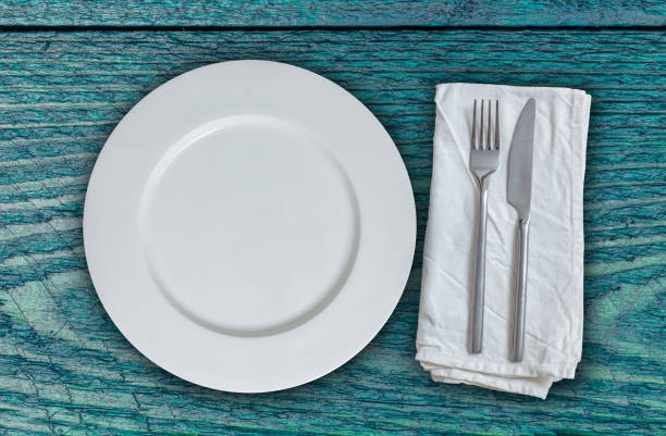istock Empty plate and cutlery on petrol colored wood 861345272