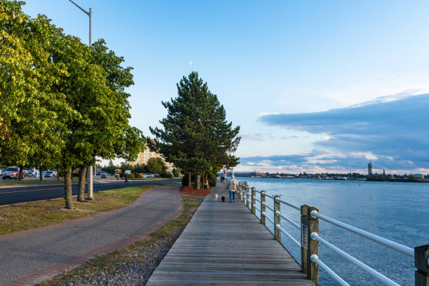 St Marys River in dusk Sault Ste. Marie, Canada - September 28, 2017: Tourists are walking on the sidewalk enjoying lakeview in Sault Ste., Marie in the dusk. marys stock pictures, royalty-free photos & images