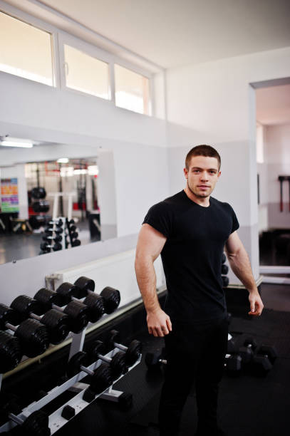 istock Young man doing exercises and working hard in gym and enjoying his training process. 861368904