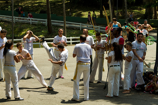 Sao Paulo, Brazil - October 12, 2017: Brazilian capoeira group performs for a crowd at an outdoor event in the Sao Paulo Capital. Young people present their skills.