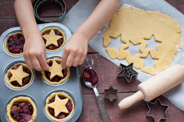 winter holidays activities with toddlers. Baking together mince pies for Christmas stock photo