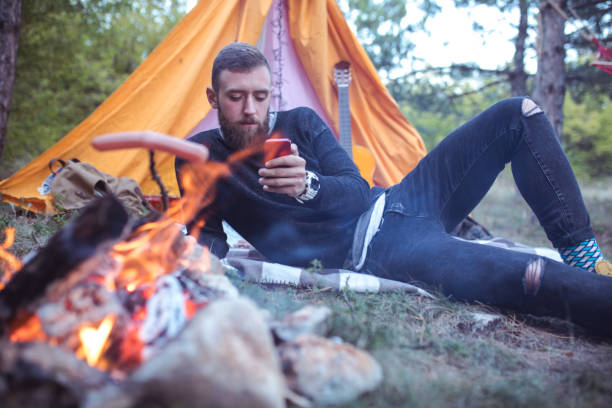 istock hiking man prepare tasty sausages on campfire 861416580