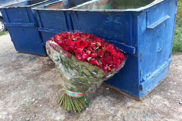 large bouquet of red roses thrown on the street the dump