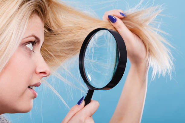 istock Woman looking at hair through magnifying glass 861442426