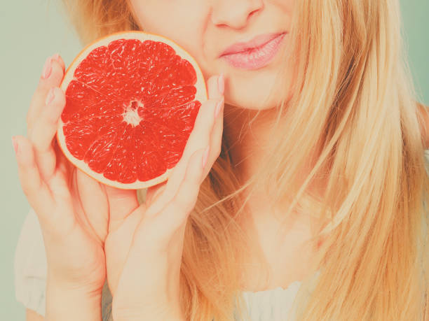 istock Woman holds grapefruit citrus fruit in hands 861442558
