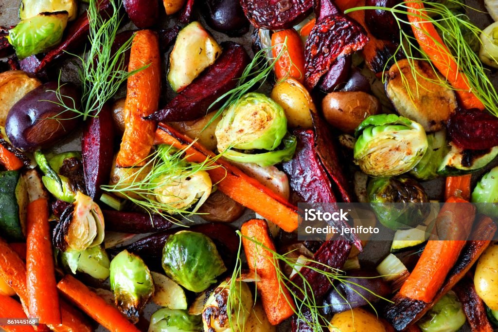 Full background of roasted autumn vegetables Full background of colorful roasted autumn vegetables, above view Vegetable Stock Photo