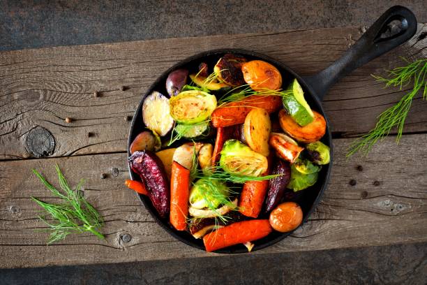 poêle en fonte de légumes d’automne rôtis - poêle verte photos et images de collection