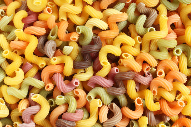 istock Food background - uncooked colorful Cavatappi (Celentani) durum wheat pasta with beetroot, spinach and tomato 861455962