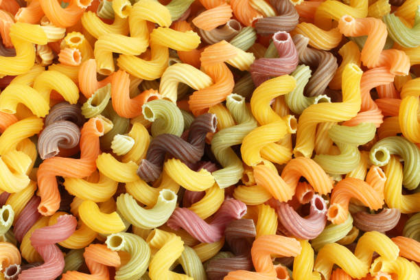 istock Food background - uncooked colorful Cavatappi (Celentani) durum wheat pasta with beetroot, spinach and tomato 861455964