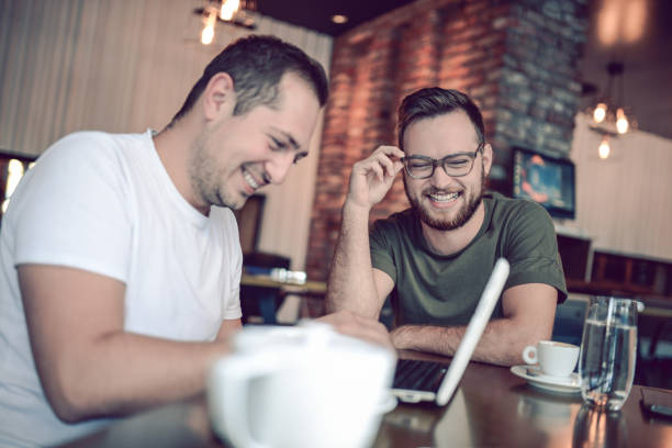 istock Two Smiling  Male Freelancers Drinking Coffee and Working In Cafe Restaurant 861456602
