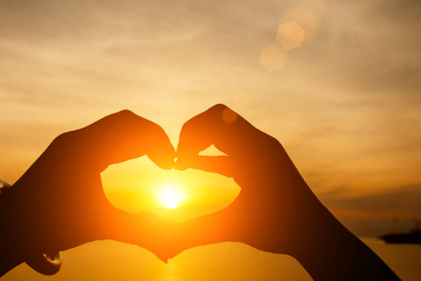 istock Silhouette sun rise in love heart hand shape 861460080