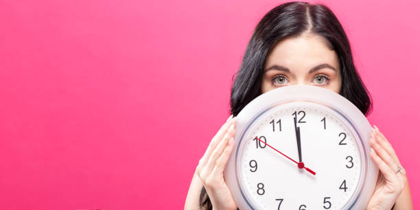 istock Woman holding clock showing nearly 12 861467456