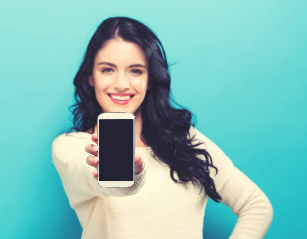 istock Young woman holding out a cellphone 861467522