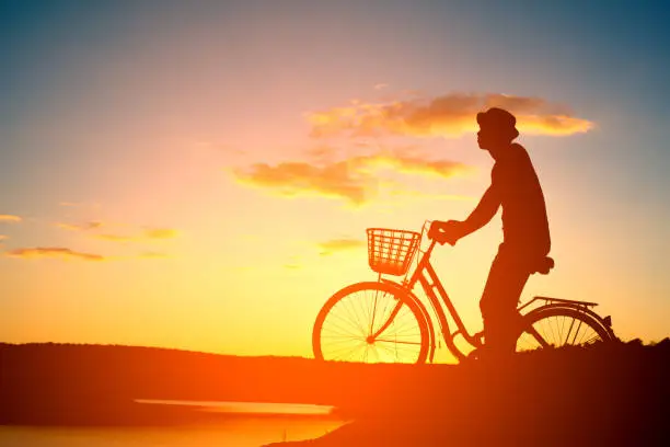 Photo of man biker in mountain with sunset background