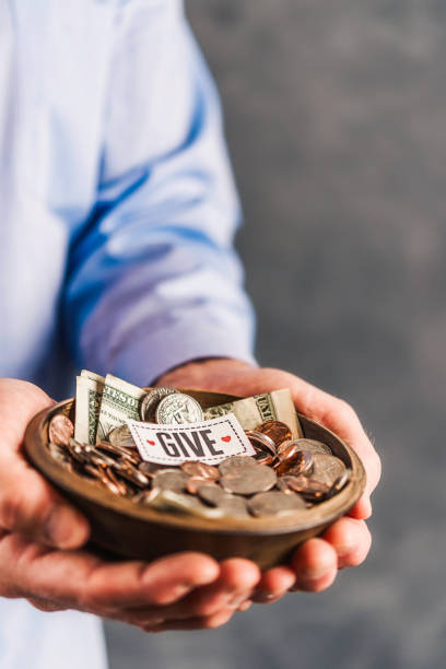 istock Male hands holding donation bowl with sign reading, Give 861493060
