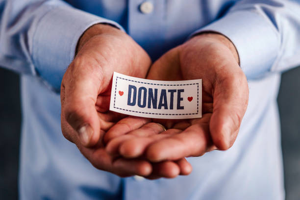 Male hands holding sign reading donate Male hands holding sign reading donate begging social issue photos stock pictures, royalty-free photos & images
