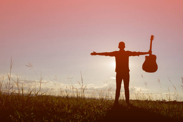 istock Silhouette man holding guitar with sunset 861496464