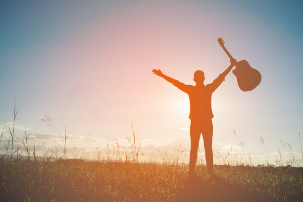 istock Silhouette man holding guitar with sunset 861496468