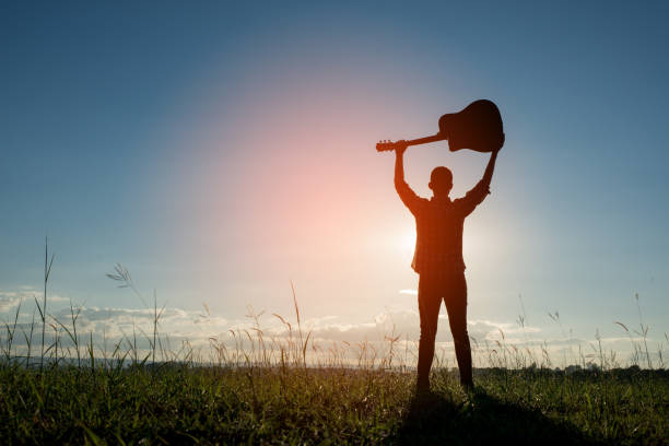 istock Silhouette man holding guitar with sunset 861496912