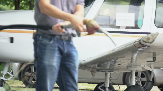 Man refuelling a airplane at a petrol station