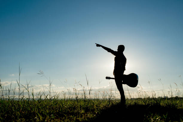istock Silhouette man holding guitar with sunset 861499684