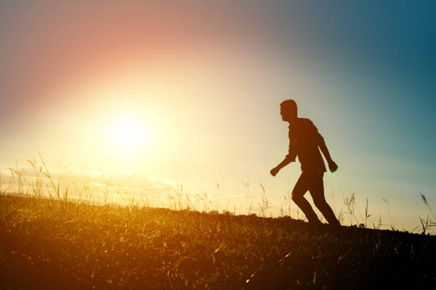 istock Silhouette of the running man at sunset background. 861499696