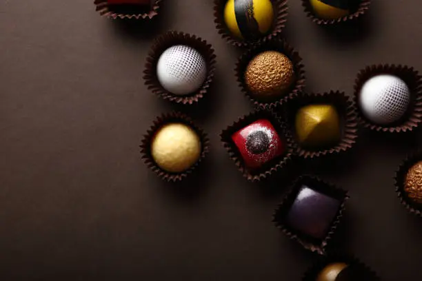 Assortment of chocolate pralines on dark background, food