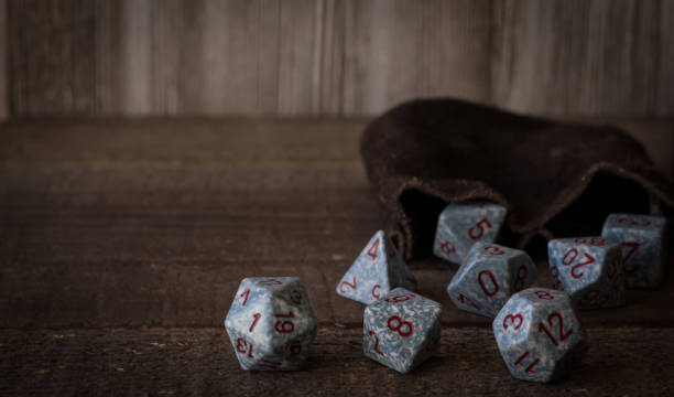 Gaming dice on a wooden table top being rolled out of a bag Gaming dice on a wooden table top being rolled out of a bag shot in natural light with subdued wood grain colors as background developing 8 stock pictures, royalty-free photos & images