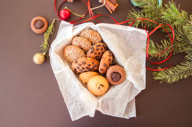 istock Christmas cookies gift box. Homemade festive baking concept, fir tree branches, balls, cinnamon, anise, red ribbon. Brown background. 861527770