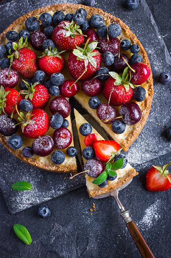 cheesecake with fresh summer berries. Top view. Dark background