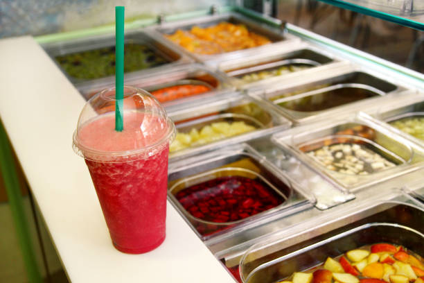 istock Fruit smoothie ready for sales in plastic cup with straw. Take away drinks concept. Fresh fruits juices at the public market. Various fresh fruit and vegetable salad bar healthy items. Healthy drink. 861549424