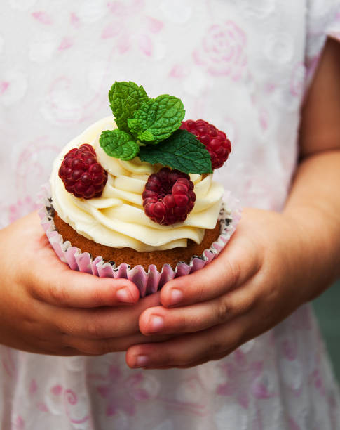 istock Little girl holding cupcake 861549716