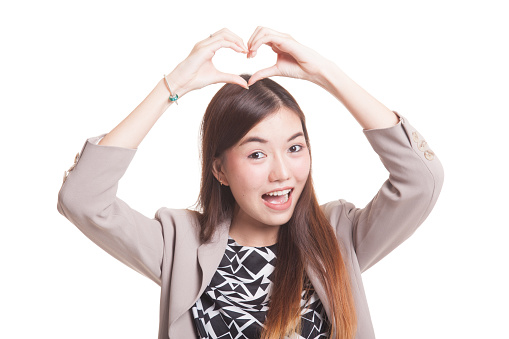 Young Asian woman gesturing heart hand sign isolated on white background