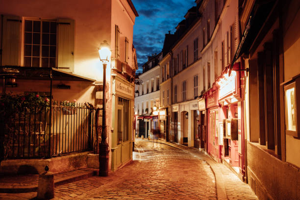 beleuchtete straßen von montmartre viertel, straße in paris bei nacht - paris straße stock-fotos und bilder