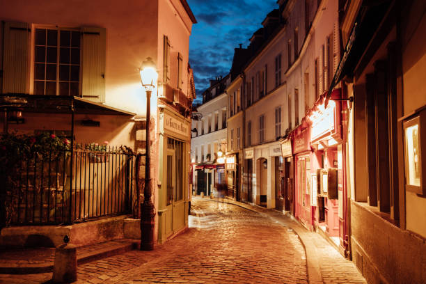Illuminated streets of Monmartre quarter, street in Paris at night Illuminated streets of Monmartre quarter, street in Paris at night cobblestone photos stock pictures, royalty-free photos & images