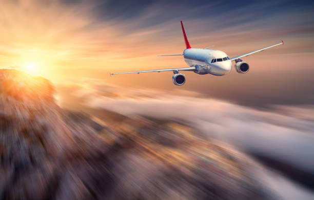 istock Airplane mith motion blur effect is flying over low clouds at sunset. Landscape with passenger airplane, blurred clouds, mountains, sun. Passenger aircraft. Business travel. Commercial plane. Concept 861592150