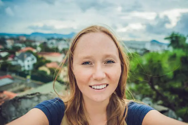 Photo of Young woman doing selfie on the background of the city of Dalat, Vietnam