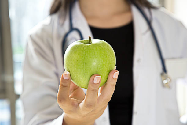 istock Female doctor holding green apple 861603872