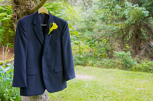 A man's tuxedo coat hanging in a tree
