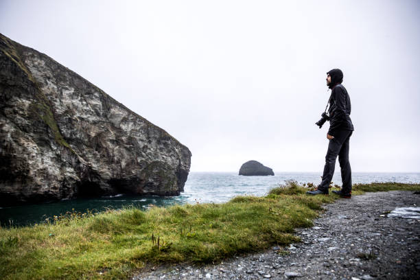 Solo traveler exploring the rocky coastline in Cornwall, UK