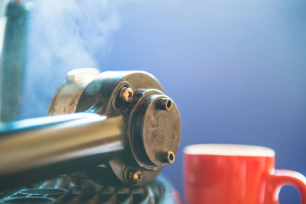 An espresso maker mount and a red cup against blue background, close-up. Nikon D800, full frame, XXXL.