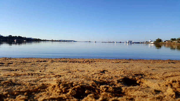 istock sand empty beach on a blue laggon at a greek island with boats 861615538