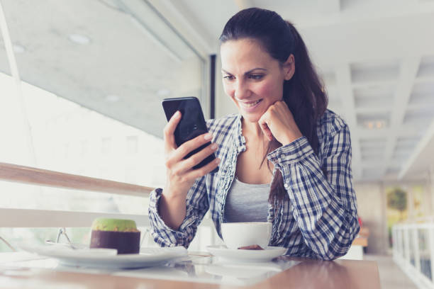 istock Beautiful young woman using smart phone in cafe, enjoy coffee break, eating cake. 861618310