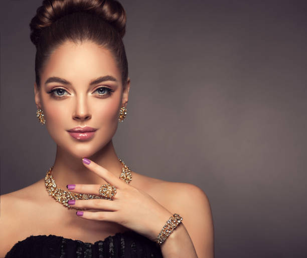 wspaniała pani w idealnym makijażu pokazuje zestaw biżuterii. - gold jewelry earring bracelet zdjęcia i obrazy z banku zdjęć