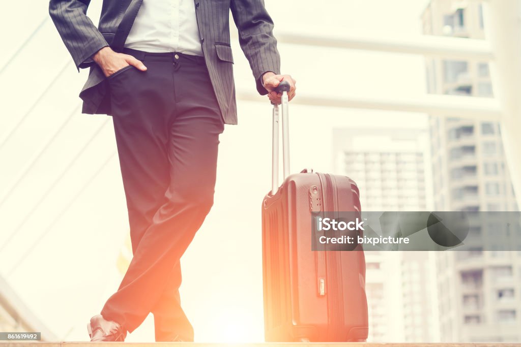 Businessmen are standing in the morning sunrise, business man going to the airport with luggage, concept of business transportation and traveling holiday leave weekend. Business Travel Stock Photo