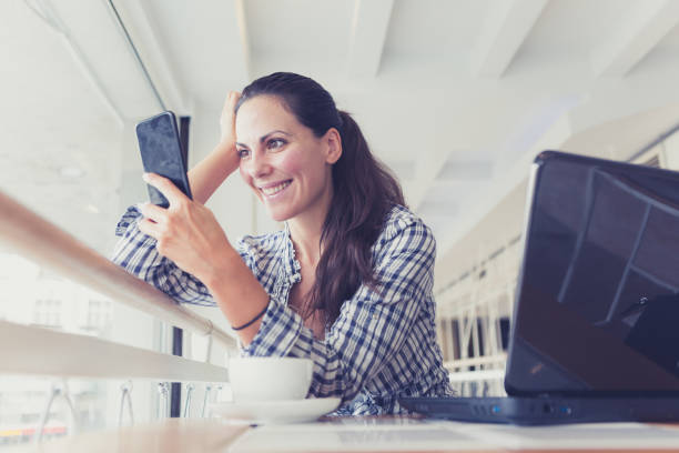 istock Young Woman freelancer using laptop and smart phone in cafe 861621790