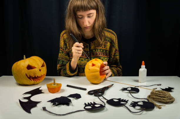istock Young female person carving jack'o'lantern for halloween 861632428