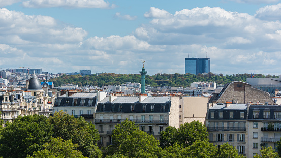 Paris, view of ile Saint-Louis, the Bastille statue and towers in background, modern and ancient buildings